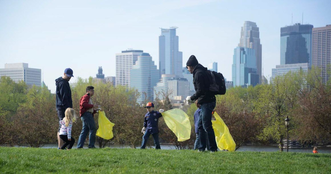 People with bags picking up litter with skyline as backdrop