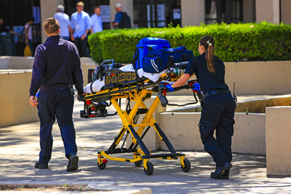 EMTs rolling a patient on a stretcher