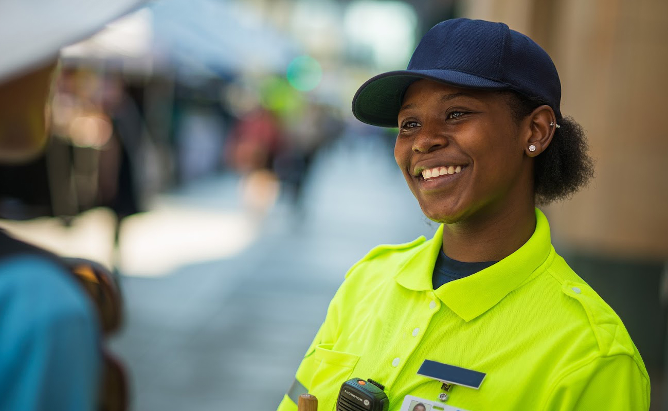 A friendly safety ambassador smiling at a community member. Photo courtesy of Minneapolis Downtown Improvement District (DID).