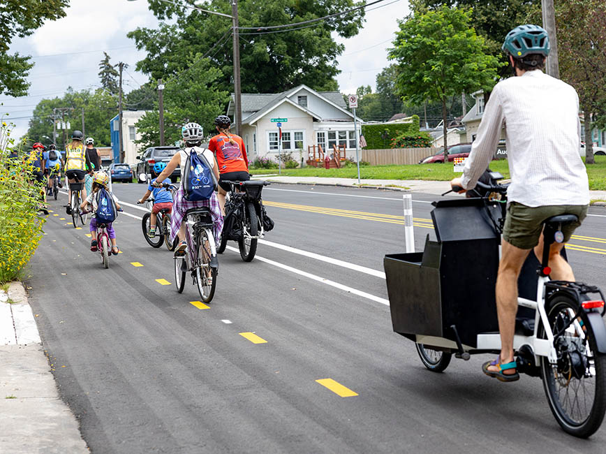 A group of people ride bicycles along a road in Minneapolis.