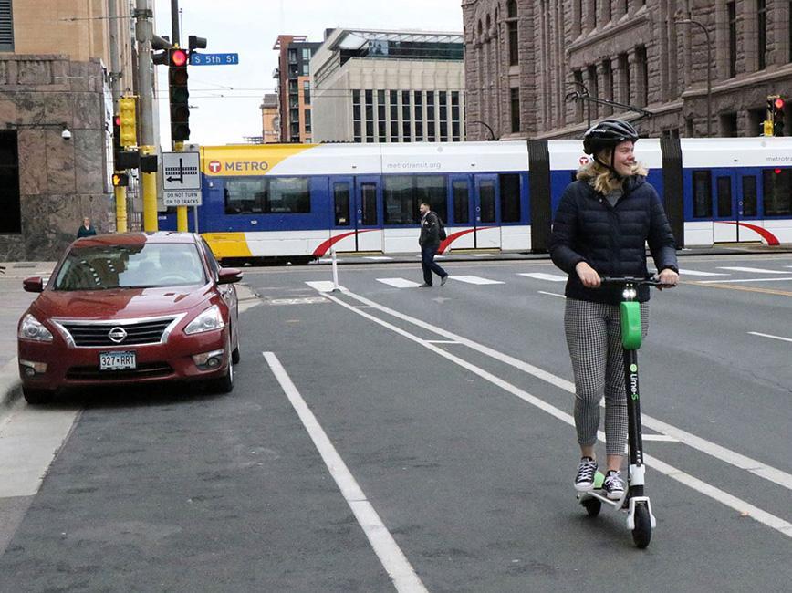 Woman riding on scooter downtown Minneapolis Woman riding on scooter downtown Minneapolis