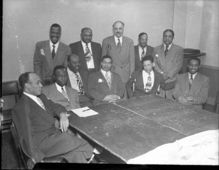 A group of African American civic leaders gathered at a table