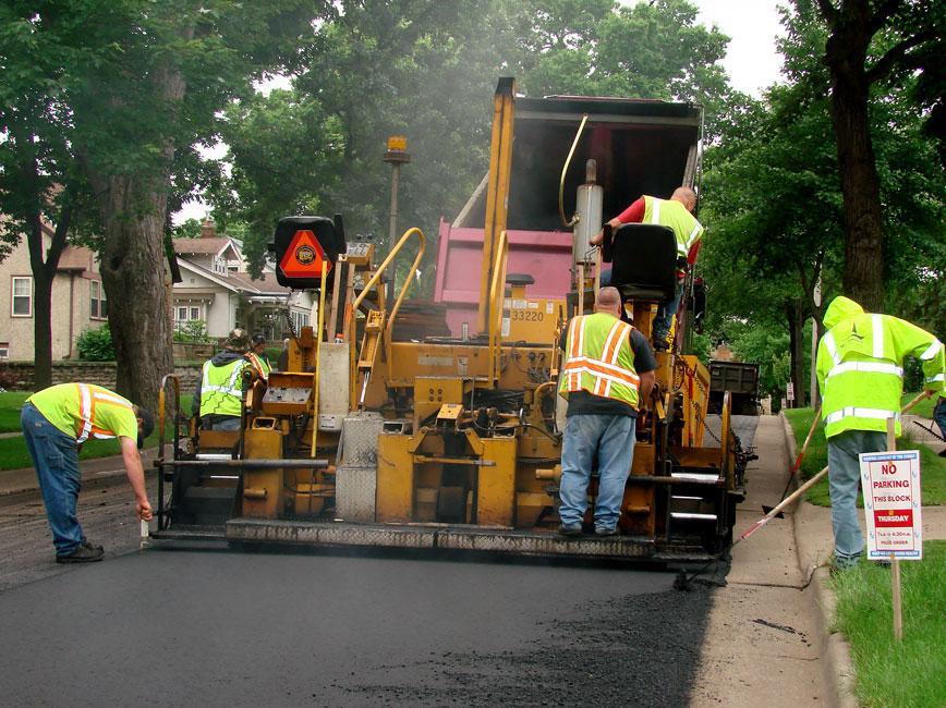 Photo of construction workers paving the road.  