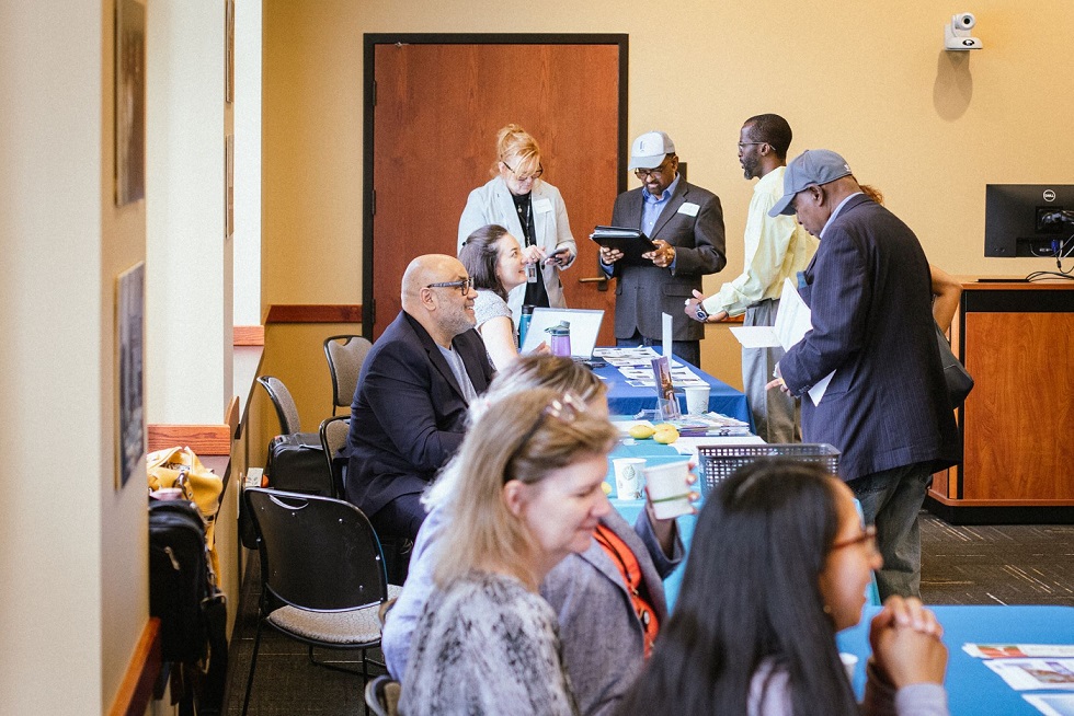 People gathered around a table both standing and sitting