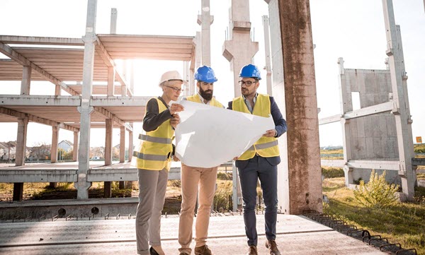 People looking at construction plans on a building site. People looking at construction plans on a building site.