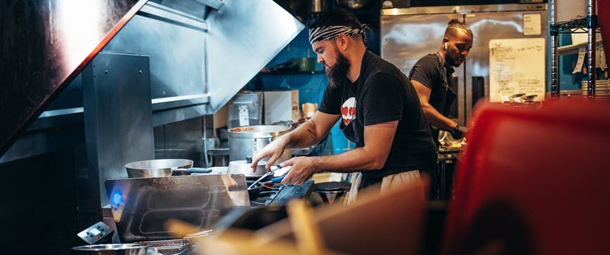 Two people working in restaurant kitchen