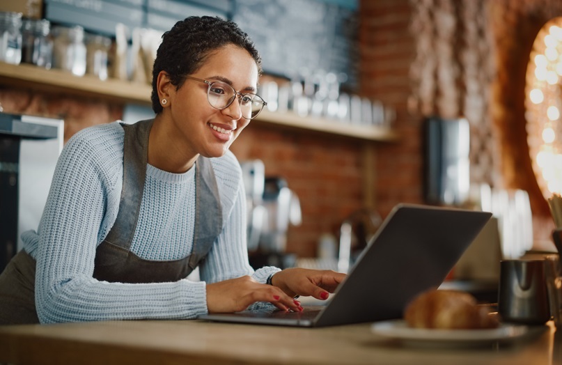 Person looking at laptop in coffee shop