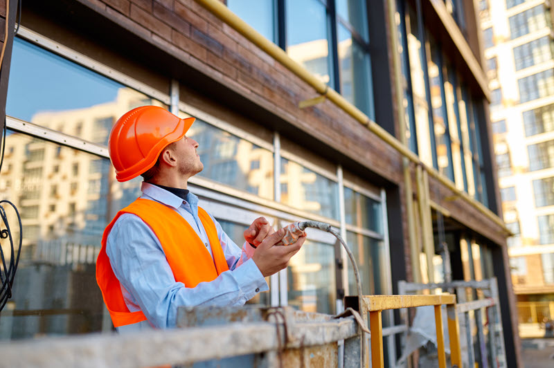 Construction worker wearing a hardhat at a construction site. Construction worker wearing a hardhat at a construction site.
