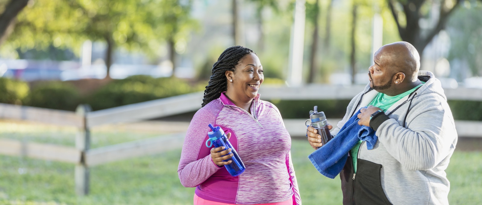Smiling couple drinking water and exercizing together