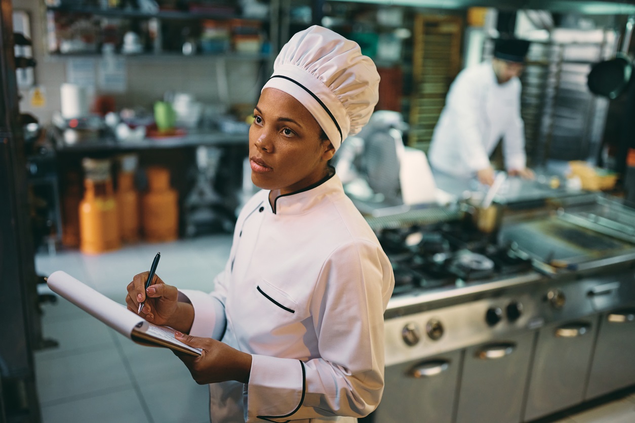 Chef with clipboard looking at food inventory