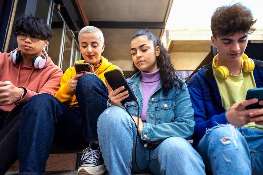 Four teenagers with phones