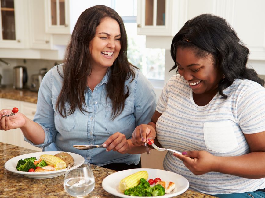 Two people smiling while eating healthy food