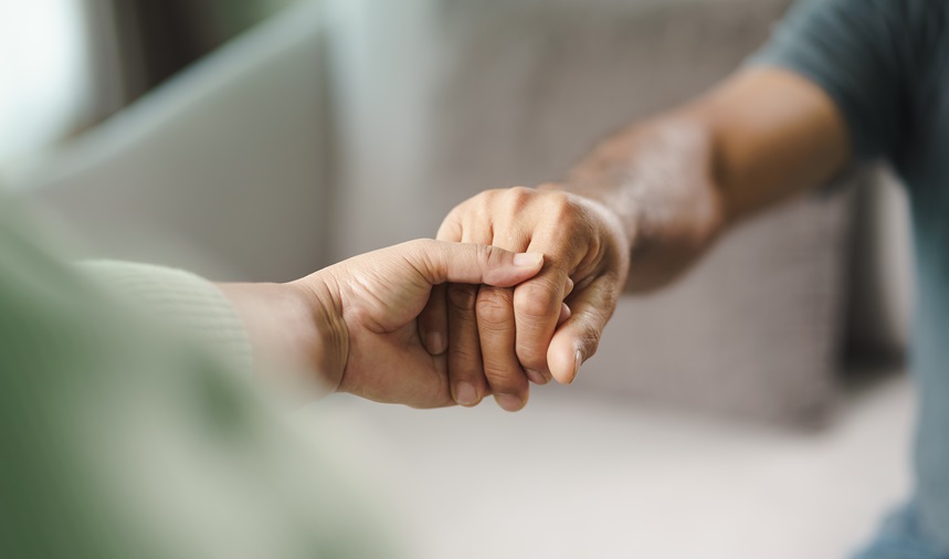 Two people holding hands in support