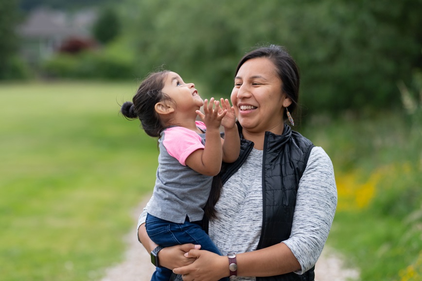 Native American child and parent together outside