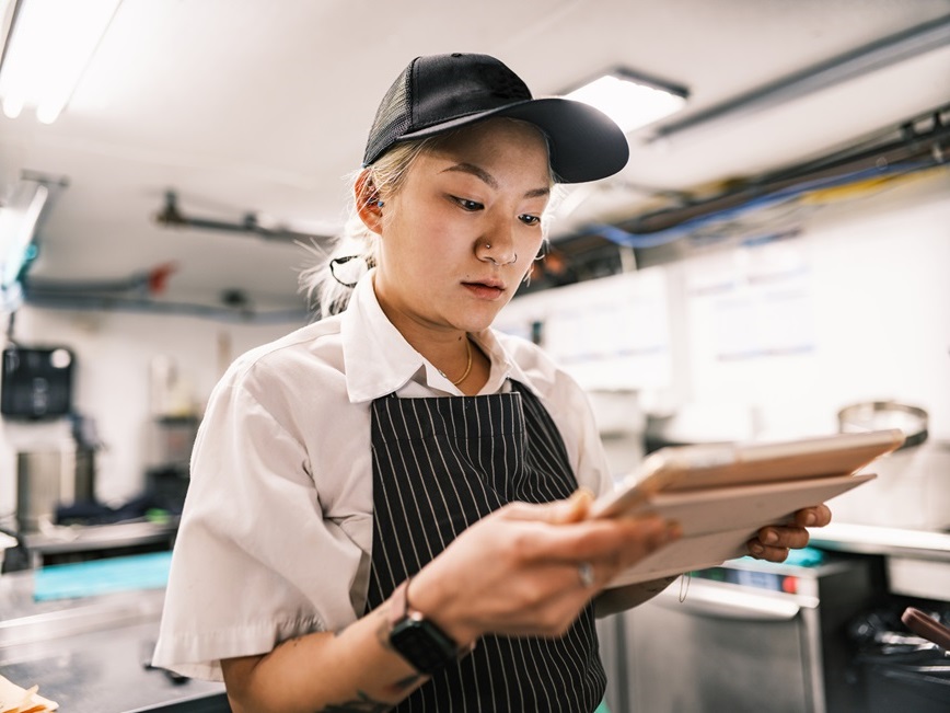 Restaurant employee looking at clipboard