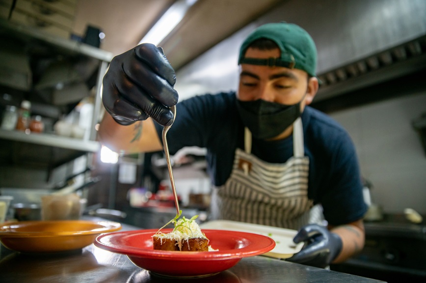 Restaurant kitchen worker checking food temperature