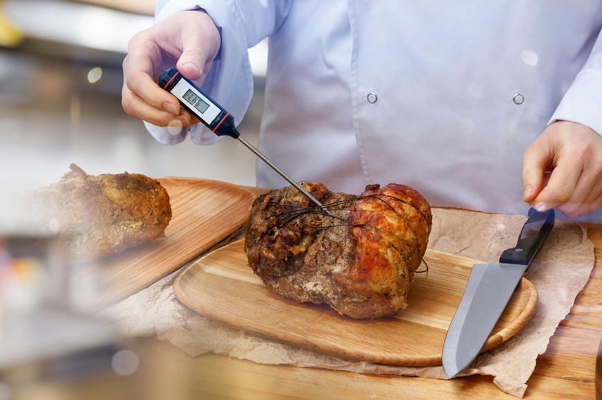 Chef checking temperature of cooked food