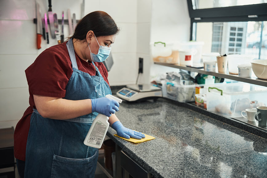 Restaurant worker cleaning counter