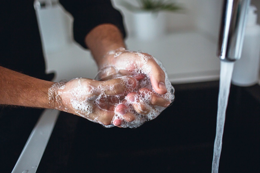 Restaurant worker washing hands in kitchen sink