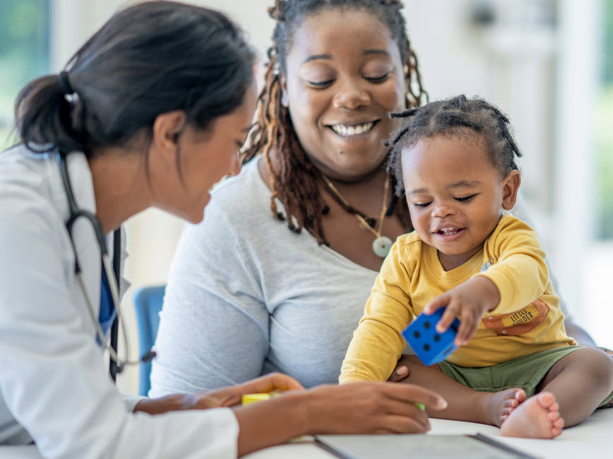 Smiling parent and child with pediatrician