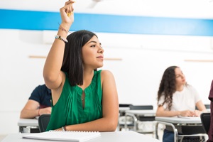 Teenager raising hand in classroom