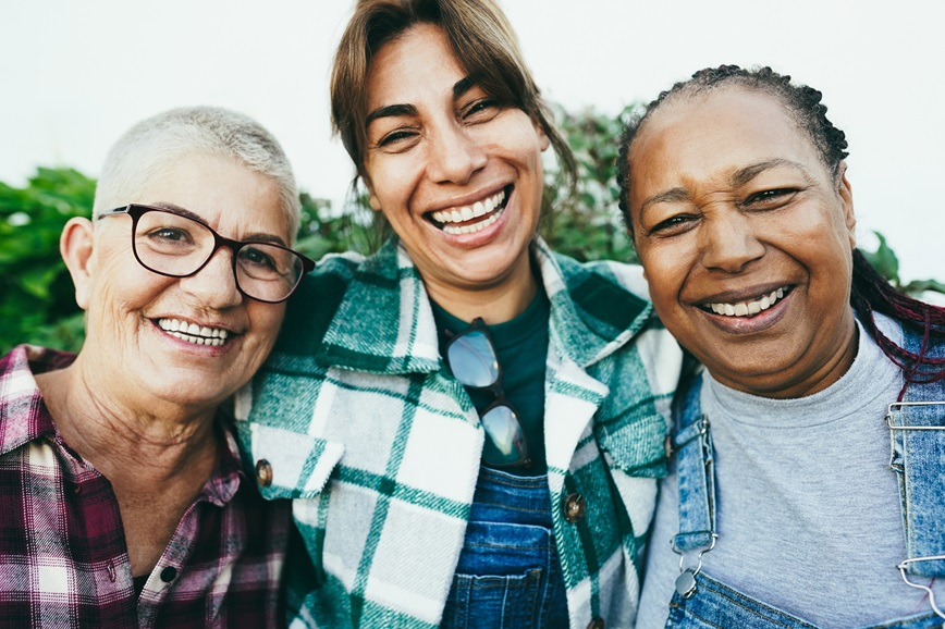 Three adults smiling outside