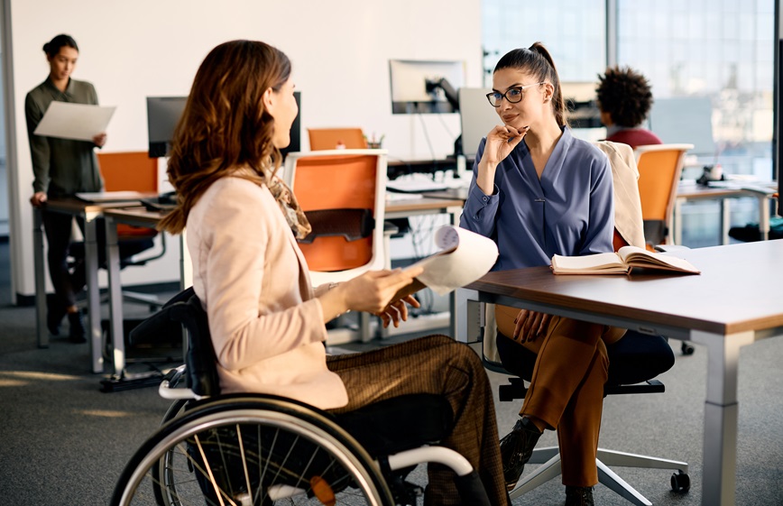 Two employees talking one in wheelchair