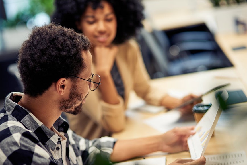 Two people reading a report. Two people reading a report.