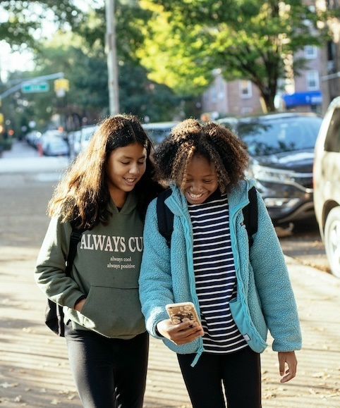 Two teenagers smiling together outside