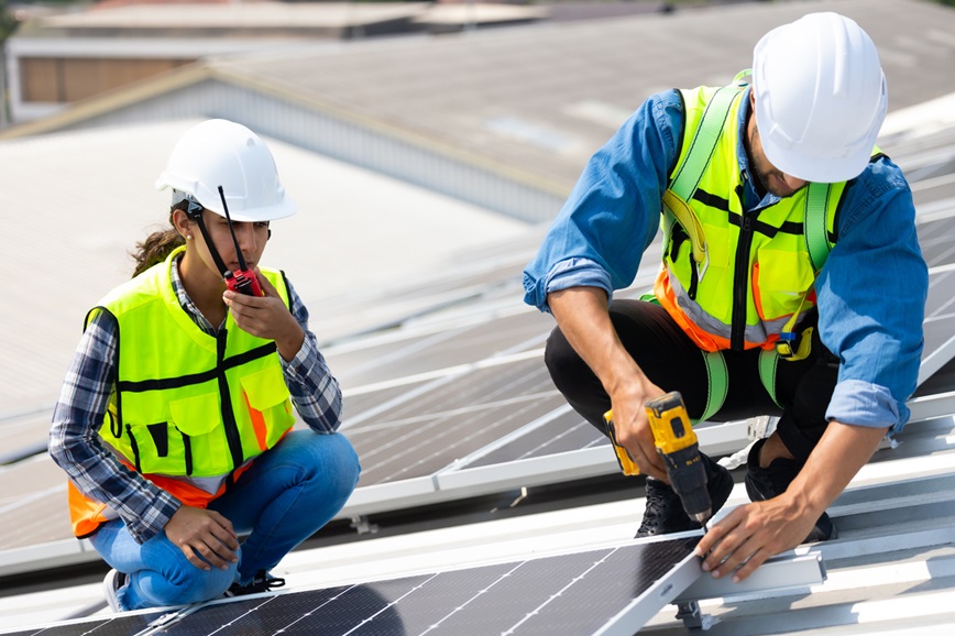 Teenager and adult working on solar panels