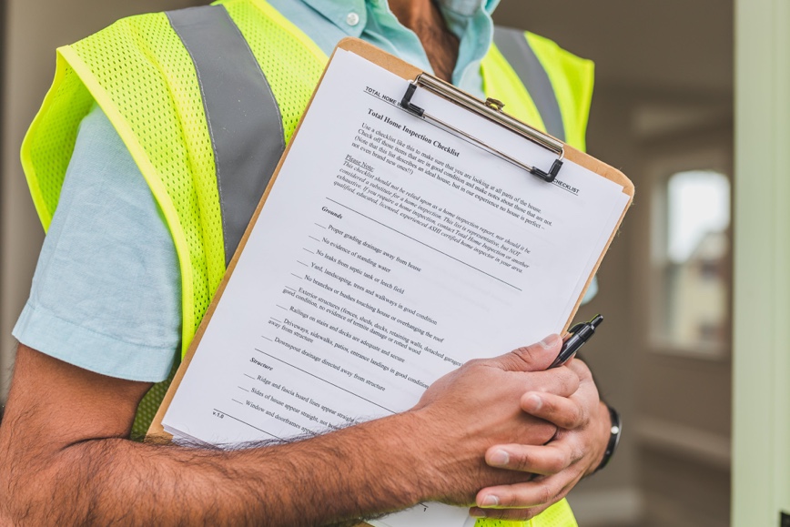 Person with yellow vest holding clipboard Person with yellow vest holding clipboard